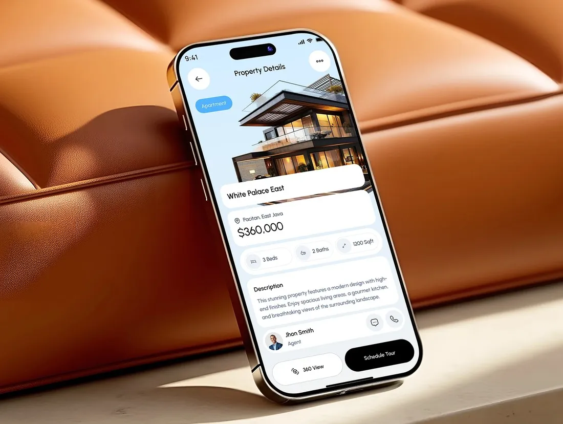 A property details screen on a phone resting on a leather sofa