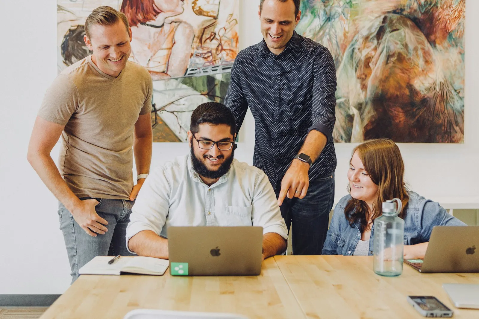 A small team gathered around a laptop, planning together
