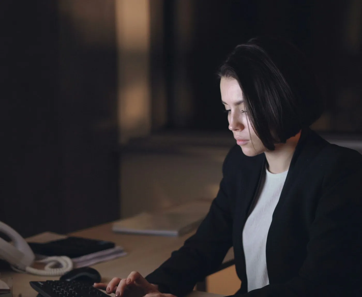 Engineer working at a computer in a dim office