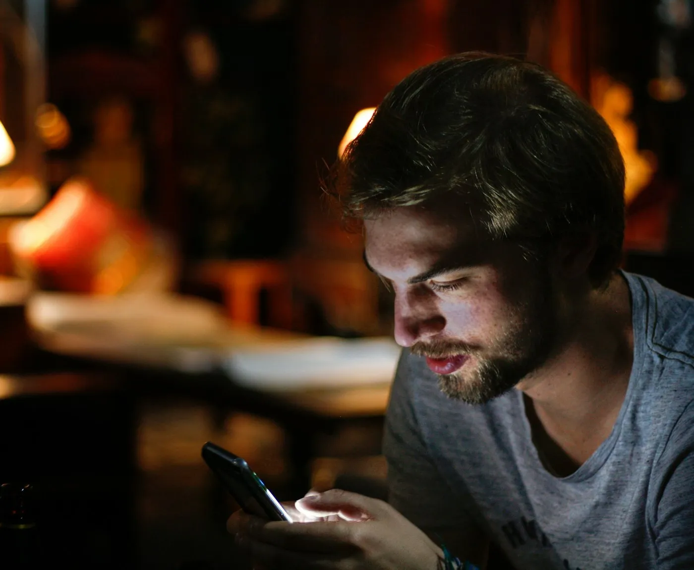 Person chatting on a smartphone in a dimly lit room