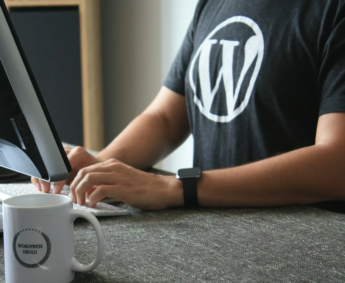 Developer working on a laptop wearing a WordPress T-shirt